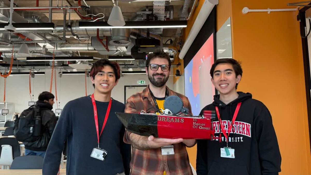 Kyle Tran and Matthew Hong holding D.R.E.A.M.S. at the final presentation