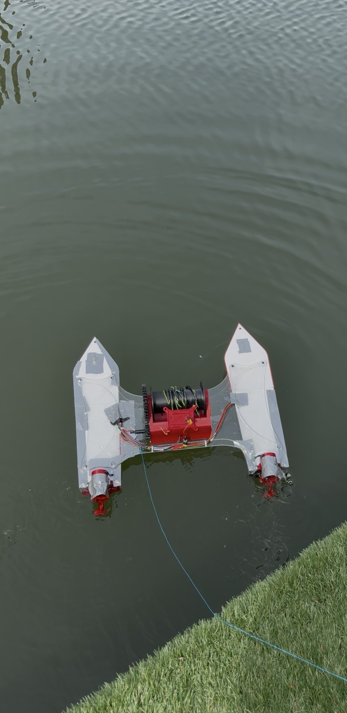 D.R.E.A.M.S. floating on the water at St Katharine Docks, seen from above, with its blue safety tether