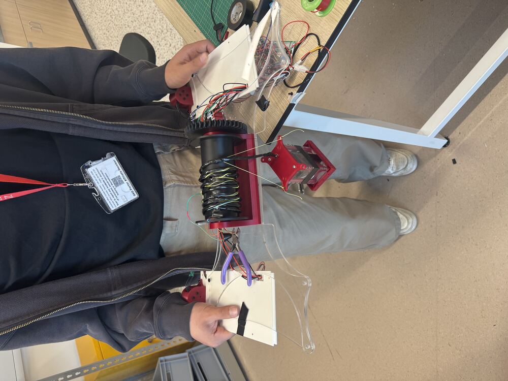 Holding the fully wired boat in the makerspace